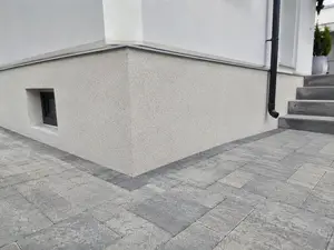 Gotowy cokół z jasnoszarego tynku mozaikowego marmolit - realizacja przy kostce brukowej
